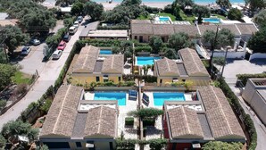 A resort with multiple swimming pools, a beach, and a view of the sea. - Barbati Beach Villas (Corfu)