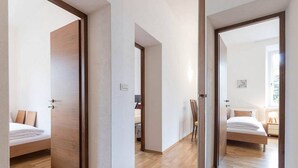 A modern hotel room with a wooden floor, a bed, a desk, and a chair. - Appartment Lissi a few steps from the centre of Merano (Meran)