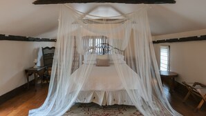 A bedroom with a canopy bed, wooden flooring, and a patterned rug. - Luxury in a Historic Landmark-great restaurants within walking distance! (Clarence)