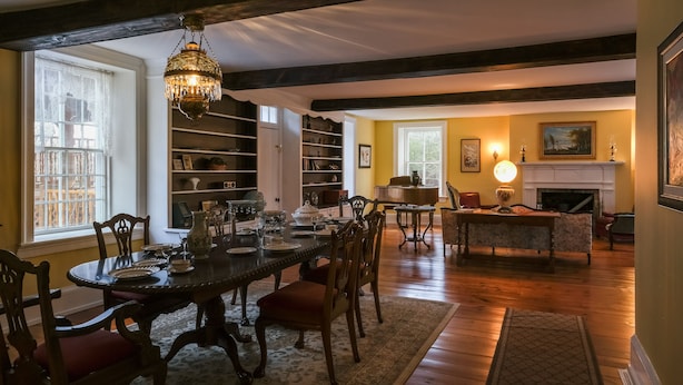 A dining room with a chandelier, wooden beams, a piano, and a fireplace. - Luxury in a Historic Landmark-great restaurants within walking distance! (Clarence)