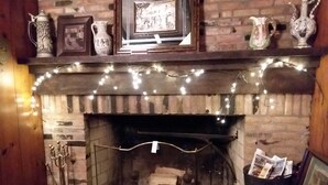 A fireplace with a brick wall, a mantel with decorative items, and a fire log storage area. - Luxury in a Historic Landmark-great restaurants within walking distance! (Clarence)