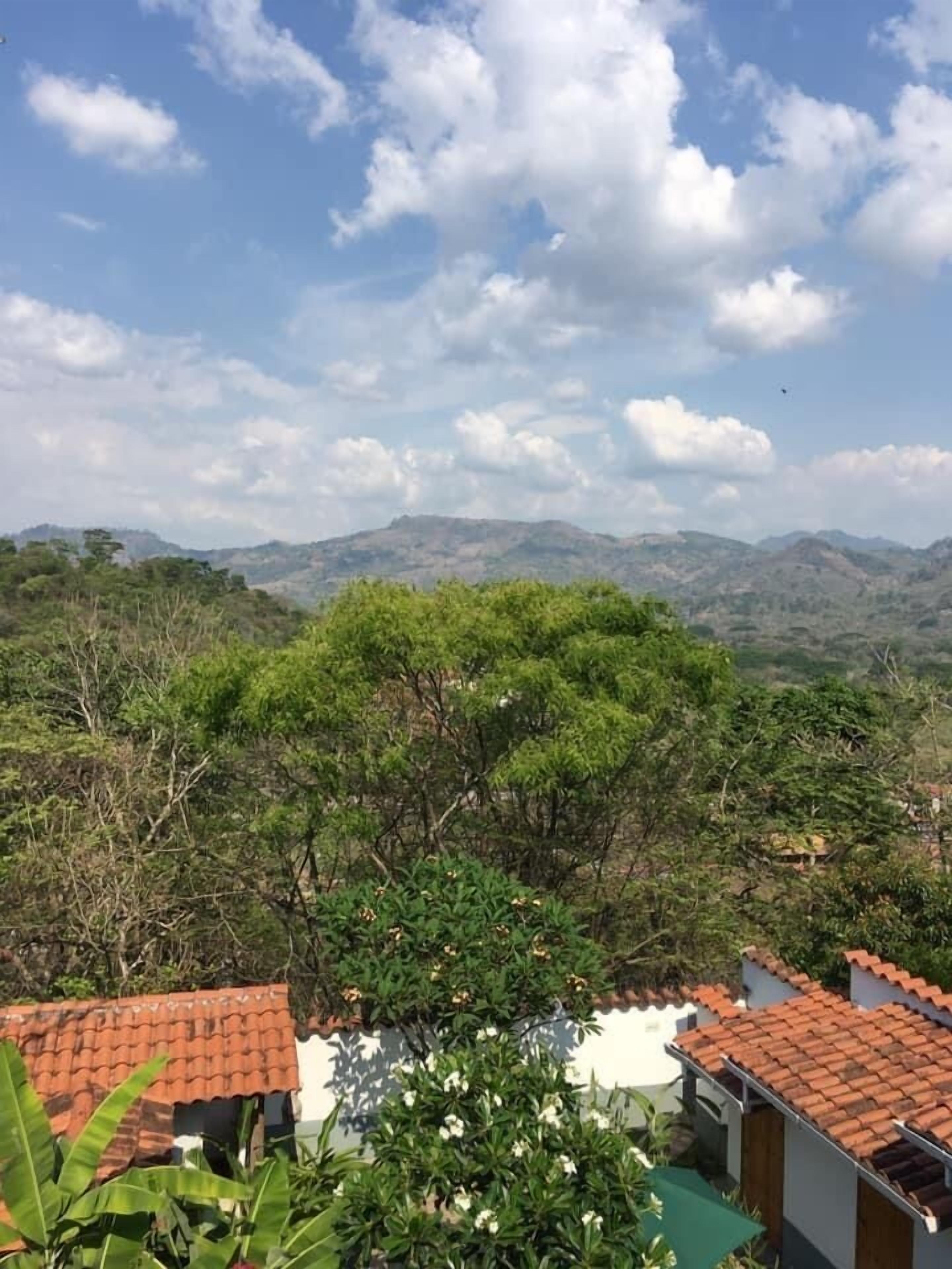 Vista de un paisaje montañoso con cielo despejado y algunas nubes dispersas.