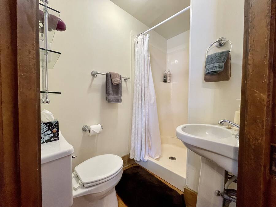 A bathroom with a toilet, a shower, and a sink.