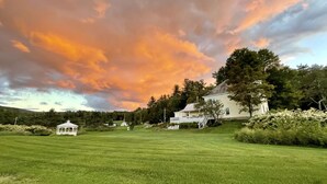 A white building with a large lawn in front.