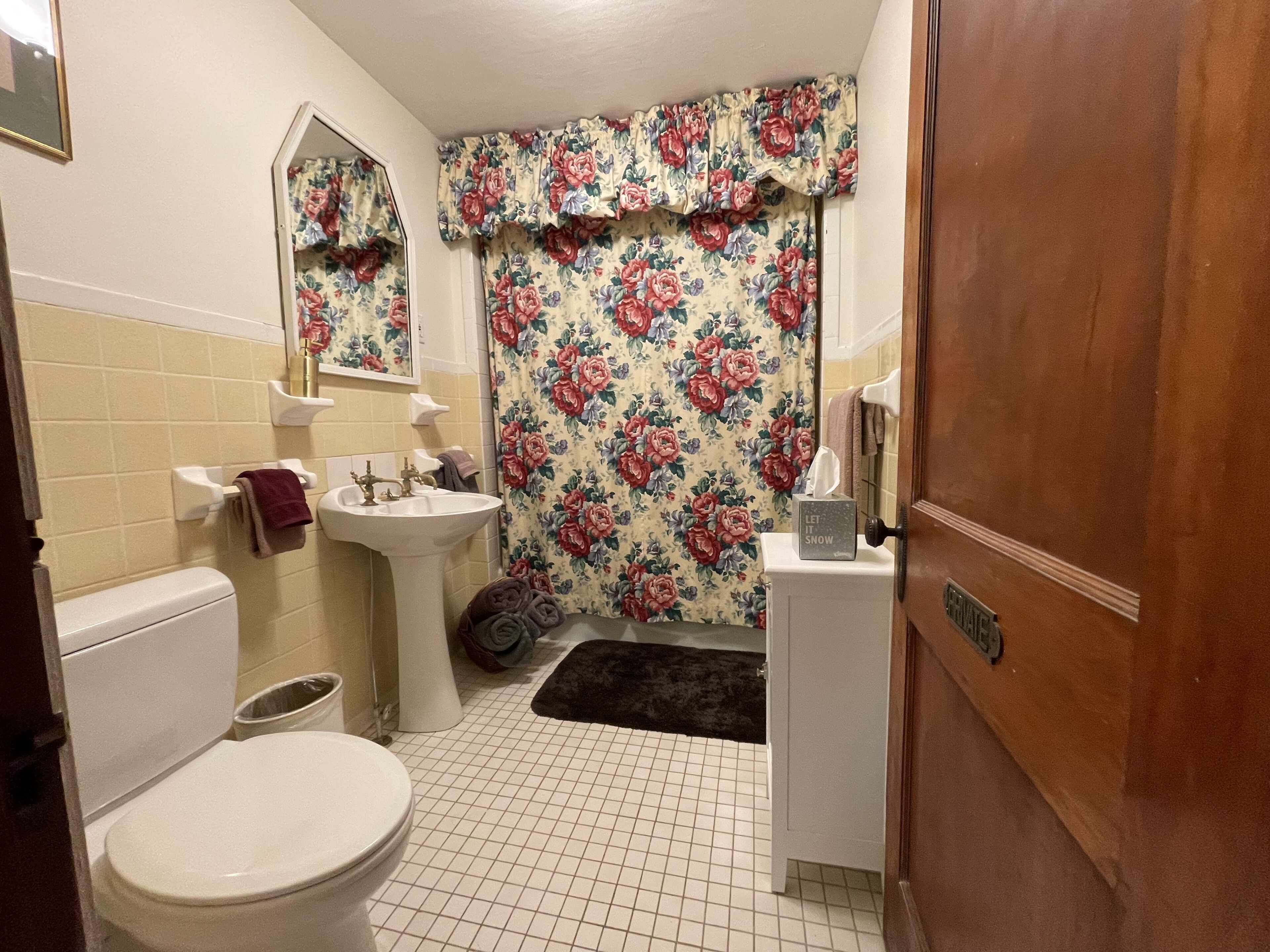 Un baño con inodoro, lavamanos y espejo.