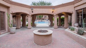A courtyard with a pool, stone columns, and potted plants. - Villa Zen 2 Bedroom Condo by RedAwning (Scottsdale)