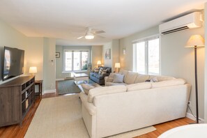 Relax in this spacious living room with a large sofa, entertainment unit, and flat-screen TV.