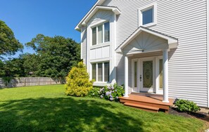 Stunning two-story home with a beautifully manicured front yard and a charming porch.