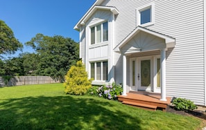 Stunning two-story home with a beautifully manicured front yard and a charming porch.