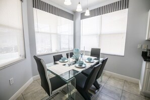 Enjoy meals in this dining area with a glass-top table and comfortable seating.