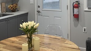Una cocina con armarios grises, una puerta blanca y un extintor en la pared.