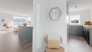 Una cocina moderna con armarios grises, un ventanal y vista al mar.