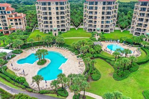 Relax by the unique pool surrounded by lush greenery and palm trees.
