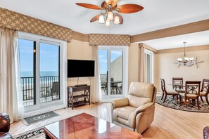 Relax in this stylish living room with a large flat-screen TV, comfortable sofa, and dining area.