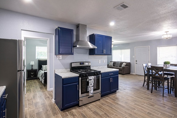 Une cuisine moderne avec des meubles de couleur bleu foncé, une cuisinière en acier inoxydable et un grand four.