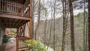 A wooden cabin with a balcony overlooking a forested area. - Blowing Rock Cabin | Hot Tub, Fire Pit, Fall Views (Blowing Rock)