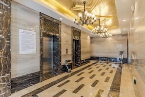 A hotel lobby with marble flooring, elevators, and a chandelier. - Xisiting Hotel (Wuhu)
