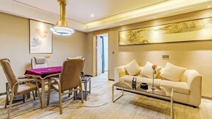 Une chambre d’hôtel moderne dotée d’un coin repas, d’un canapé et d’une table basse.