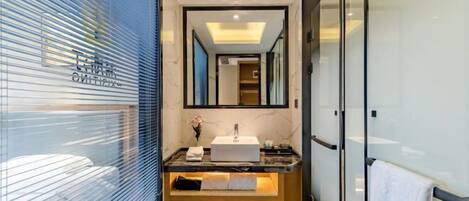A modern bathroom with a large mirror, a sink, and a wooden vanity.
