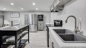 Una cocina moderna con electrodomésticos de acero inoxidable, encimera de mármol y horno empotrado.