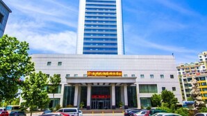 A tall, modern building with a prominent entrance and a sign above it. - Jincheng Hotel (Linqu)