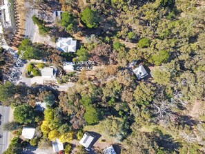 An aerial view of Aurora Cottage, featuring a cluster of buildings surrounded by dense forest. - Aurora Cottage at Hepburn Mineral Springs Reserve (Hepburn Springs)