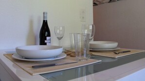 Un comptoir de cuisine avec un saladier blanc, une bouteille de vin et deux verres à vin.