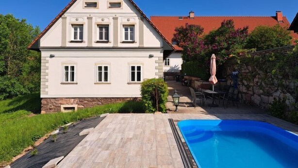 A two-story house with a swimming pool, stone wall, and outdoor furniture. - Vacation home Frilo by Interhome (Broumov)