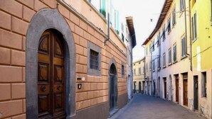 Une rue étroite, bordée de bâtiments des deux côtés, qui se distingue par ses portes et fenêtres en arc de cercle.