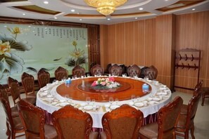 Une salle de conférence équipée d’une table ronde, de chaises et d’un mur décoratif.