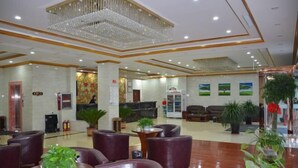 A spacious lobby with leather seating, a reception desk, and a chandelier. - Kaiyuan Business Hotel (Zhuolu)