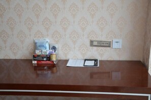 Una recepción con un espejo, un bloc de notas y algunos objetos encima.