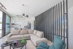 Relax in this open-plan living space with a large sofa and modern kitchen area.