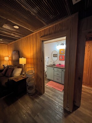 Ein Holzinterieur mit einer Couch, einer Lampe und einem Korb.