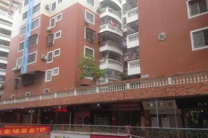 A multi-story building with balconies, a small tree, and a storefront with signage. - 100 Inn (Fuqing Chenglong Pedestrian Street) (Fuqing)