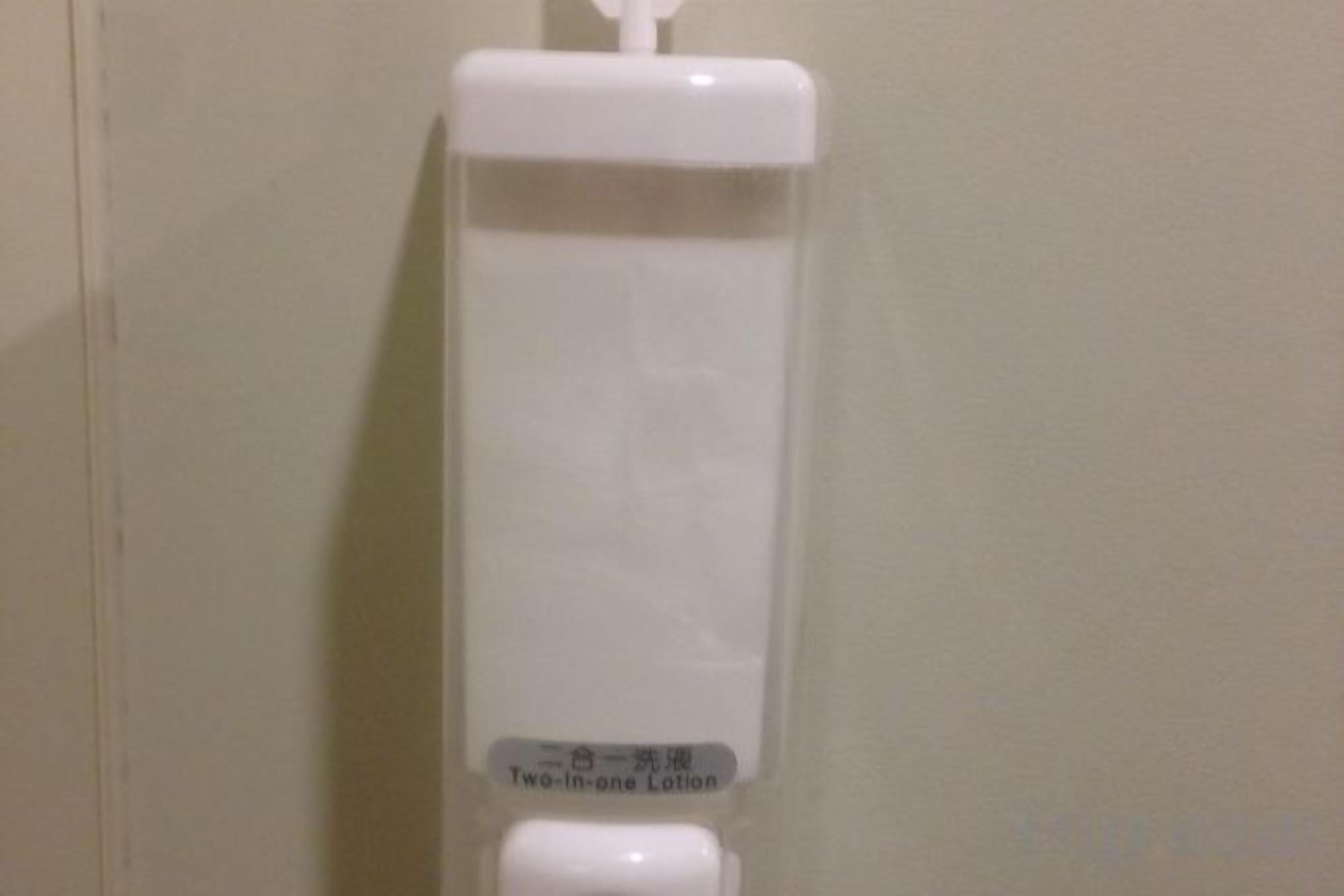 A dispenser with a label that reads 'Two-in-one Lotion.'