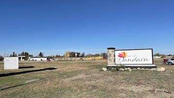 Señal del pueblo de Dundurn, con cielo despejado y un campo verde en primer plano.
