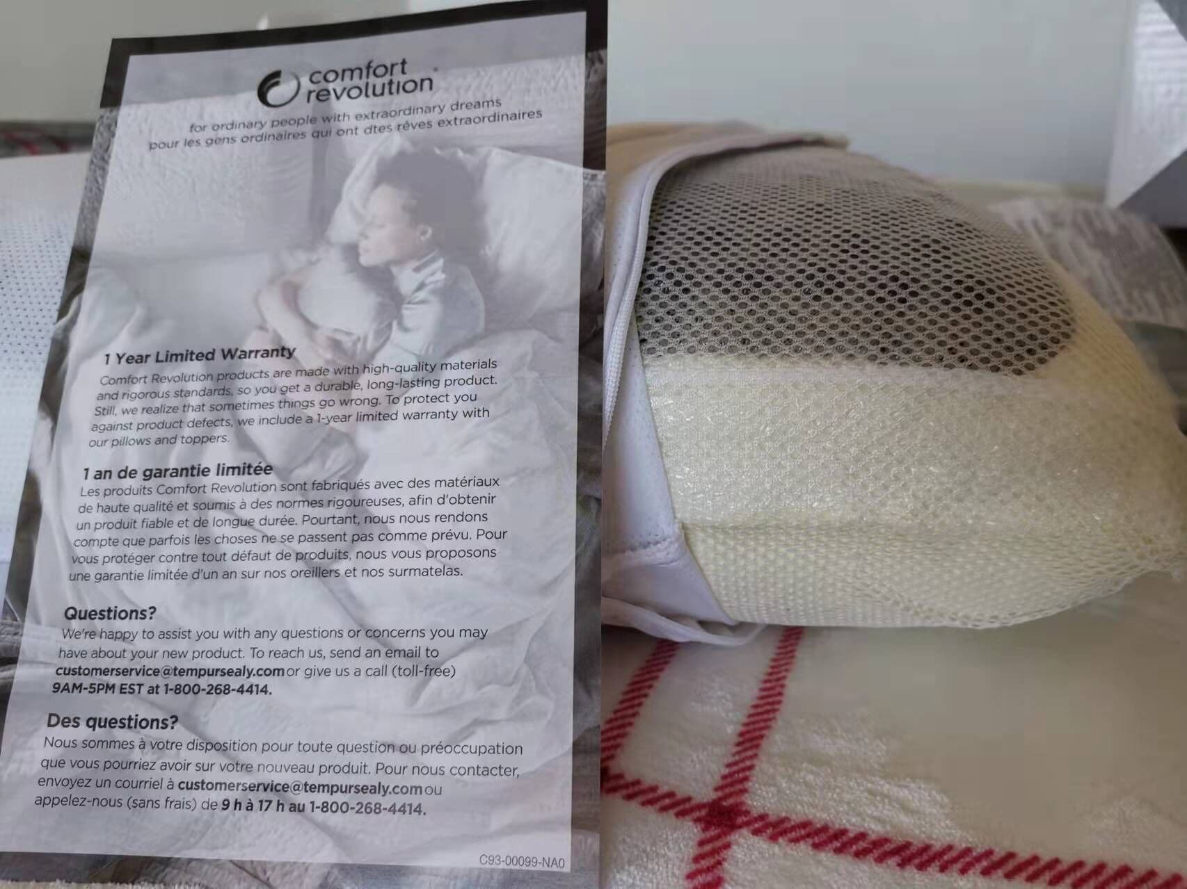 Almohada con una etiqueta que detalla una garantía limitada de un año e información de contacto del servicio al cliente.