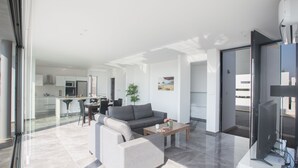 Una sala de estar moderna con sofá, mesa de centro y televisor de pantalla plana.