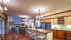 A spacious kitchen with a central island, wooden cabinets, and stainless steel appliances. - Perfect View (Davis)
