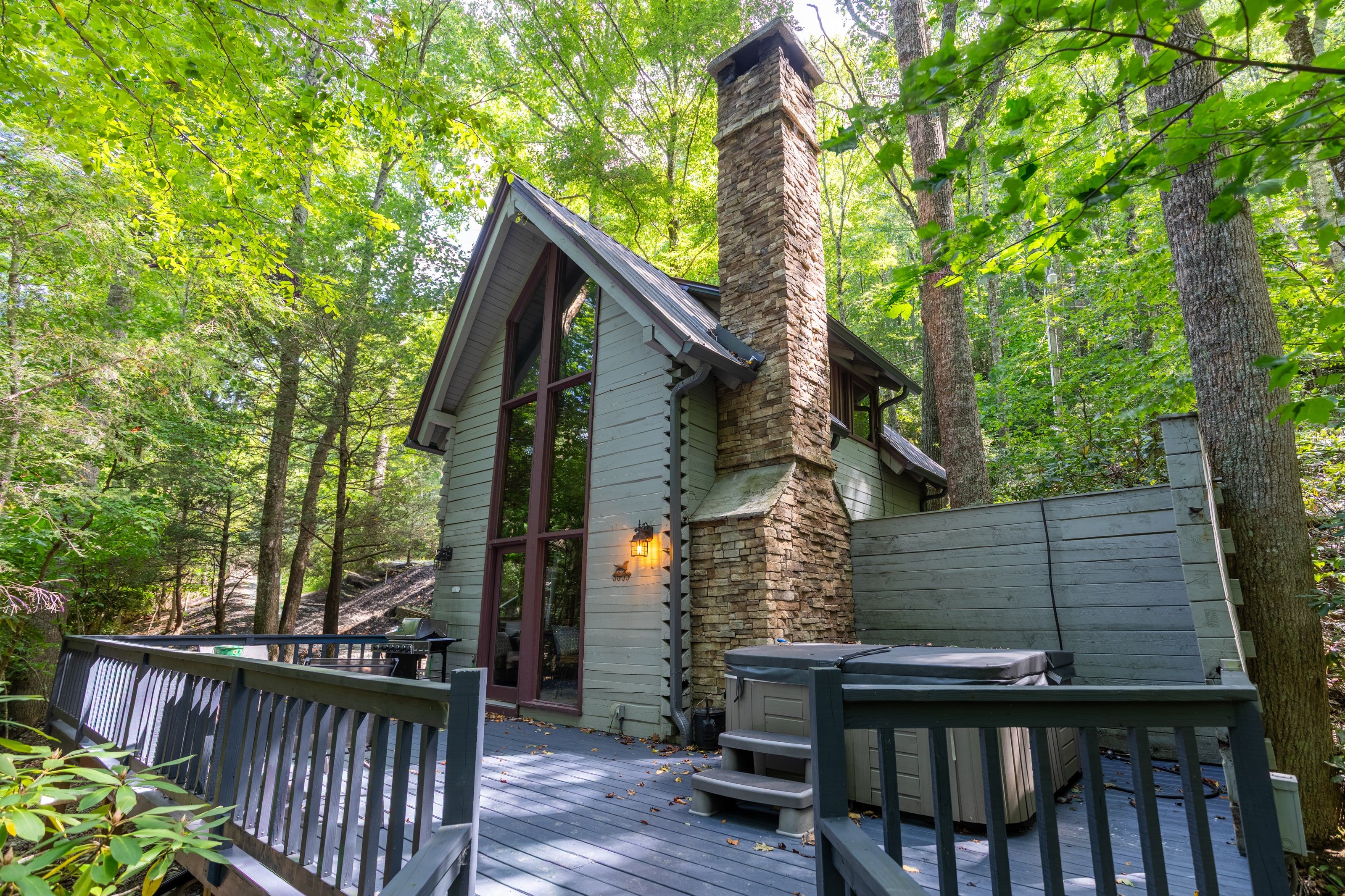 Towering stone chimney and open air deck with your own hot tub greet you at The Dog House