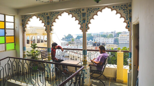 A balcony with ornate railings and a view of a cityscape. - Dreamyard Udaipur - Hostel (Udaipur)