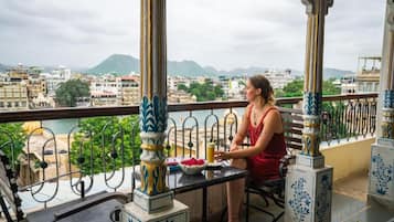 A balcony with a view of a cityscape and mountains.