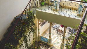A multi-level interior with a staircase, balconies, and a view of the outside. - Dreamyard Udaipur - Hostel (Udaipur)