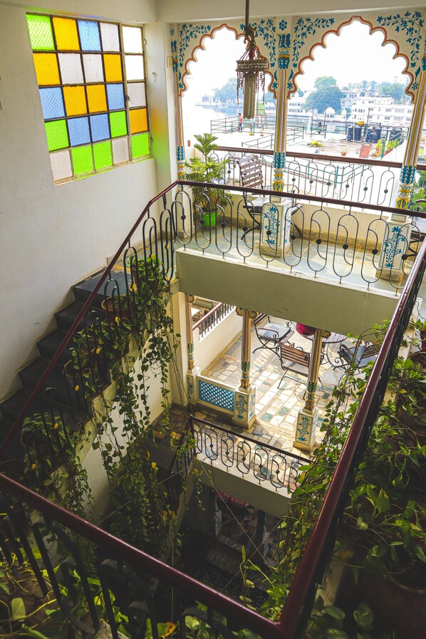 A multi-level interior with a staircase, balconies, and a view of the outside. - Dreamyard Udaipur - Hostel (Udaipur)