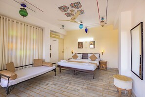 A room with a bed, a sofa, a small table, and a decorative ceiling. - Dreamyard Udaipur - Hostel (Udaipur)