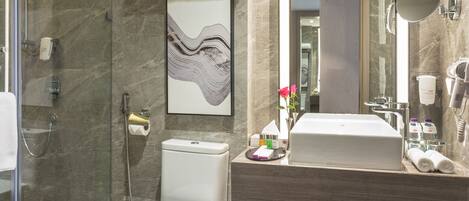 A modern bathroom with a glass-enclosed shower, a toilet, a sink with a mirror, and a marble floor.