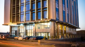 A modern hotel building with a prominent sign, multiple floors, and a well-lit entrance. - Aber Khamis Mushait (Khamis Mushait)