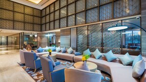 A spacious lobby with a modern design, featuring a large seating area with sofas and armchairs, a patterned wall, and a large window providing a view of the interior. - Aber Khamis Mushait (Khamis Mushait)