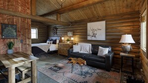Interieur van een blokhut met een bed, een bank, een houten salontafel, een vloerkleed en een lamp.